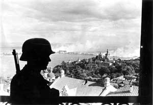Один из постов Вермахта в Киеве, захваченном накануне. На заднем плане горит разрушенный мост через Днепр