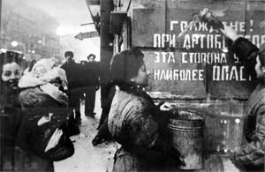 Ленинградцы закрашивают надпись «Граждане! При артобстреле эта сторона улицы наиболее опасна», январь 1944 года