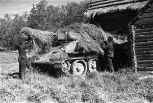 Бойцы 122-й танковой бригады маскируют танк Т-34, сентябрь 1941 года
